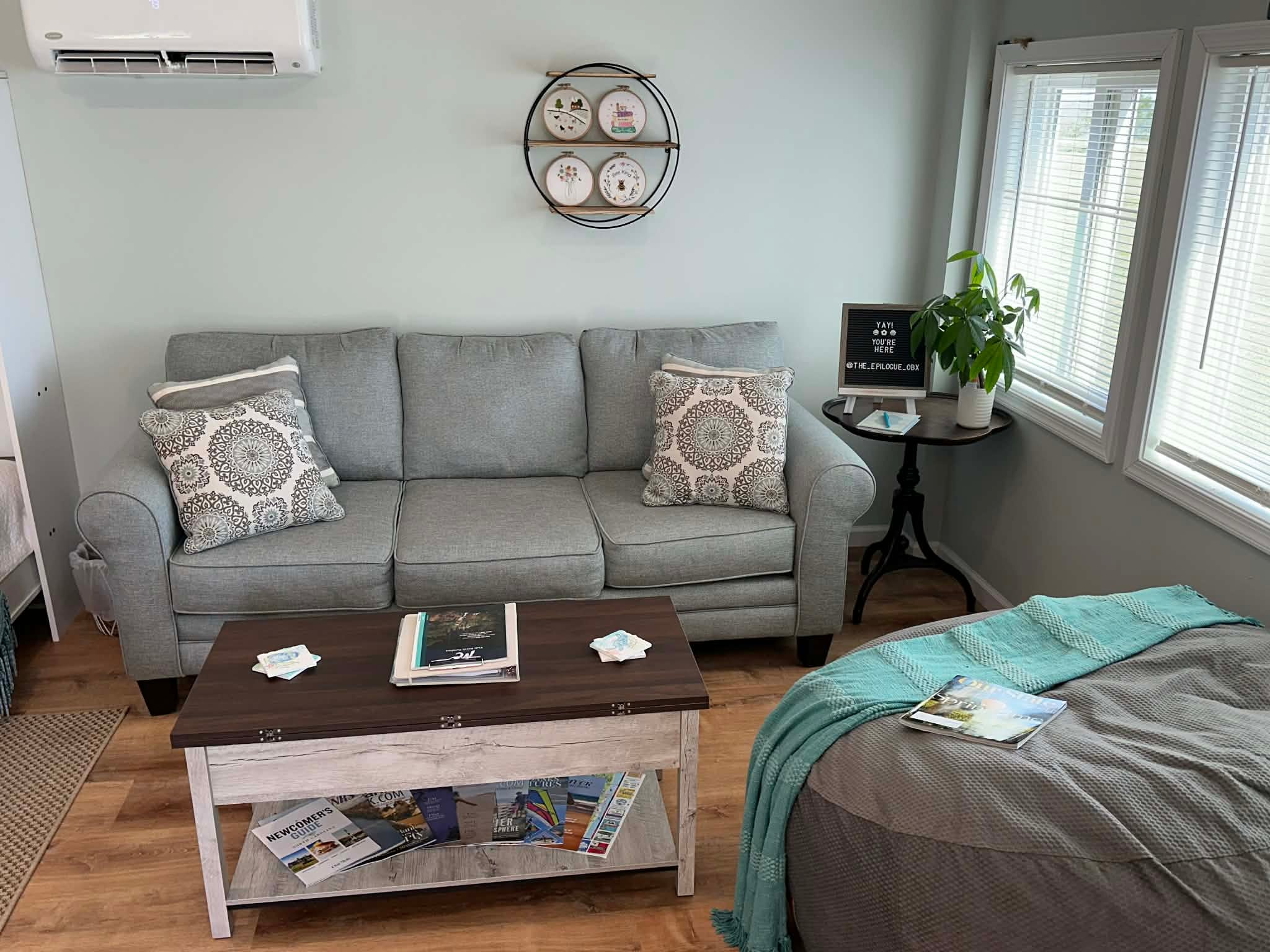 Cozy guesthouse living space with a gray sofa, coffee table, and bed