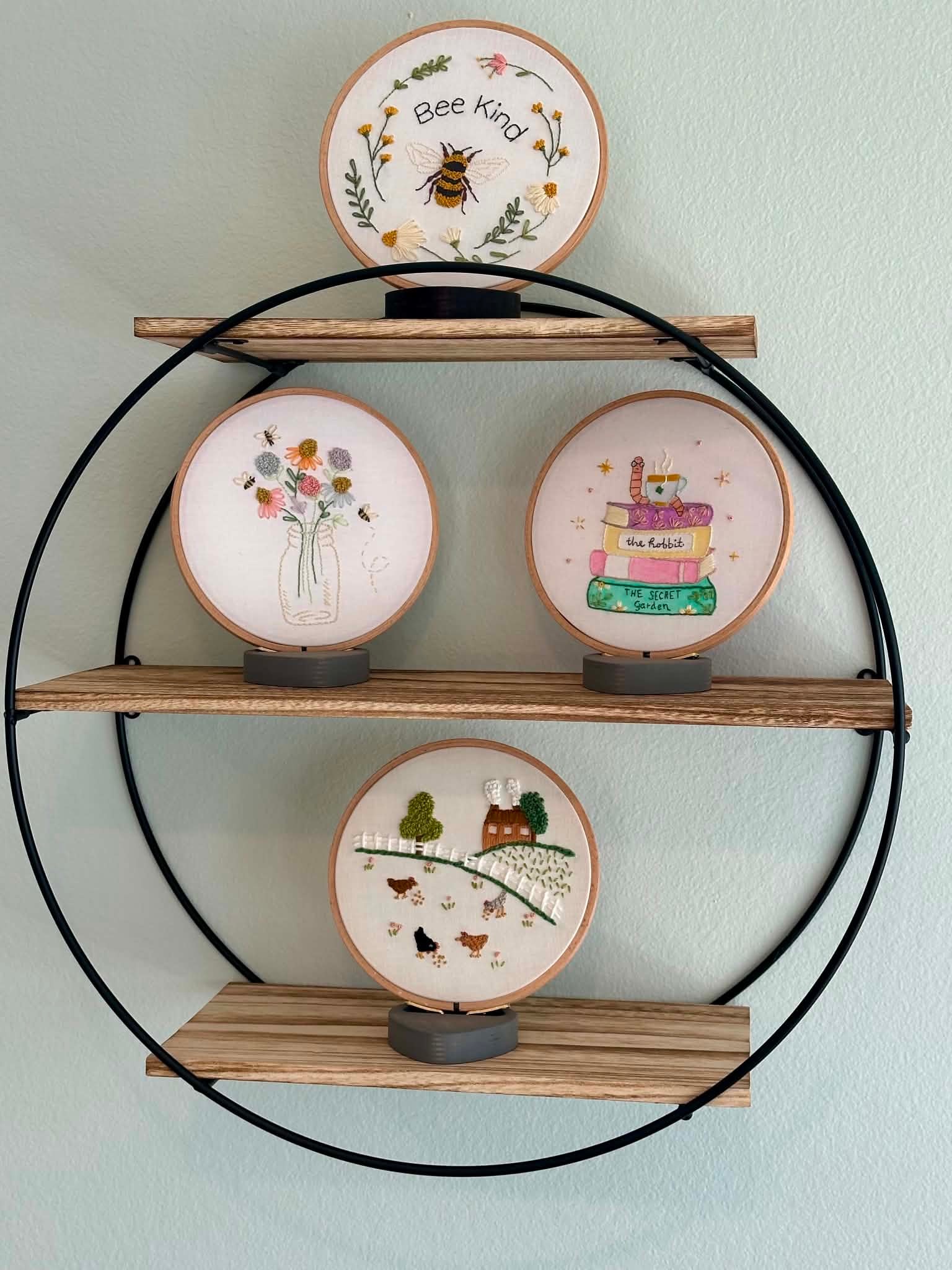 Circular wall shelf displaying embroidered hoop artwork