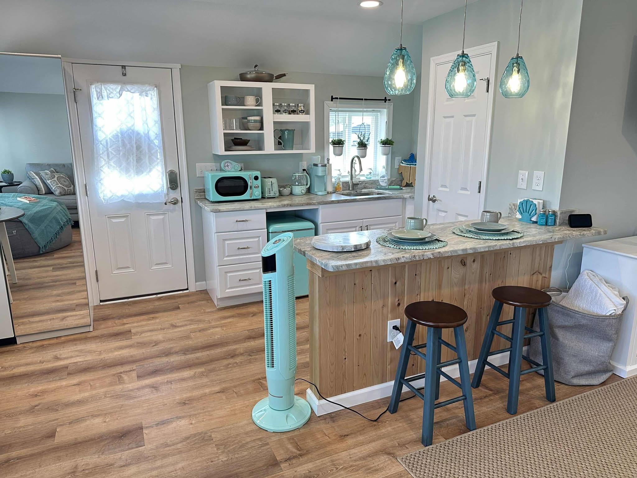 Turquoise kitchen with island and pendant lights