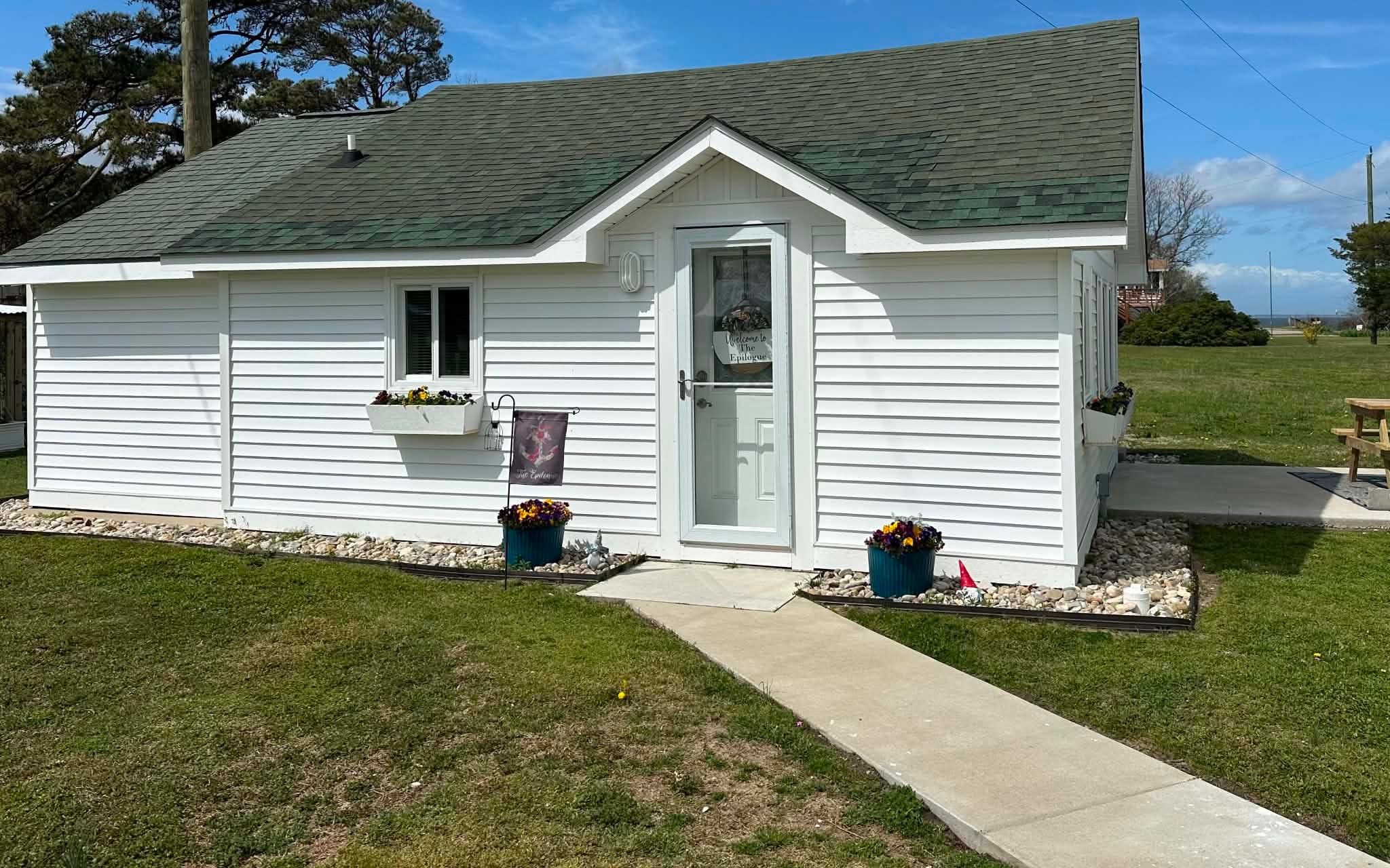 White cottage with flower planters and walkway