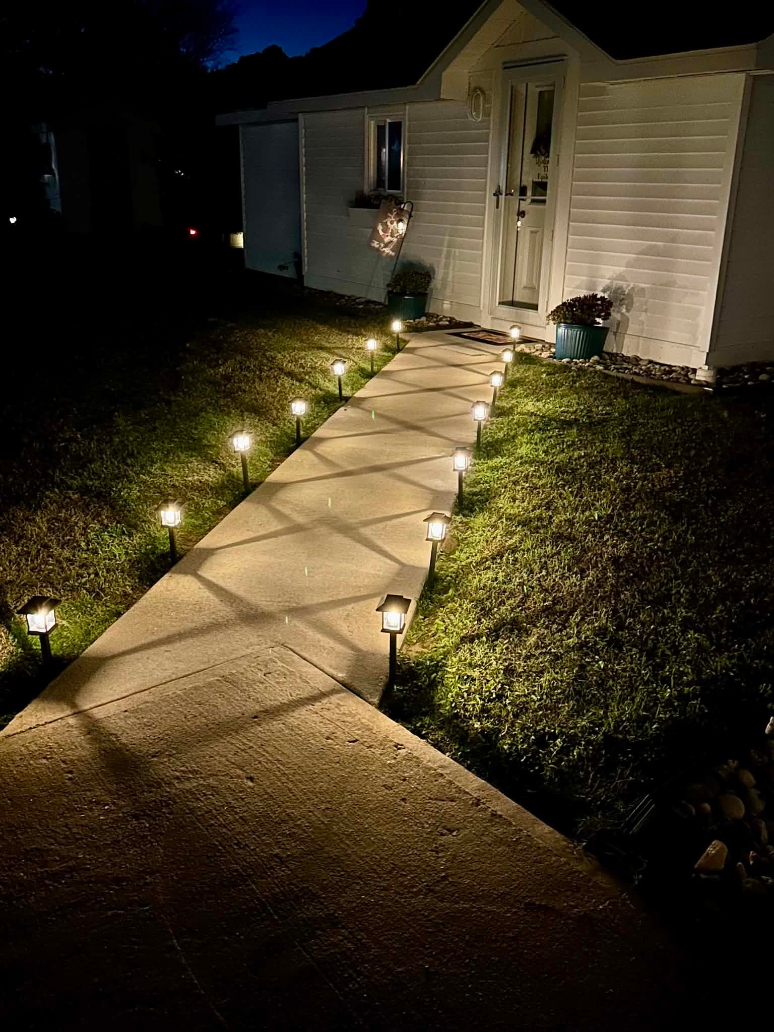 Guesthouse entrance with a warmly lit walkway at night