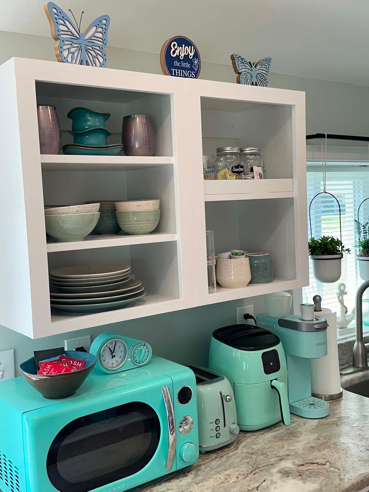 Turquoise coffee station with retro appliances and open shelving