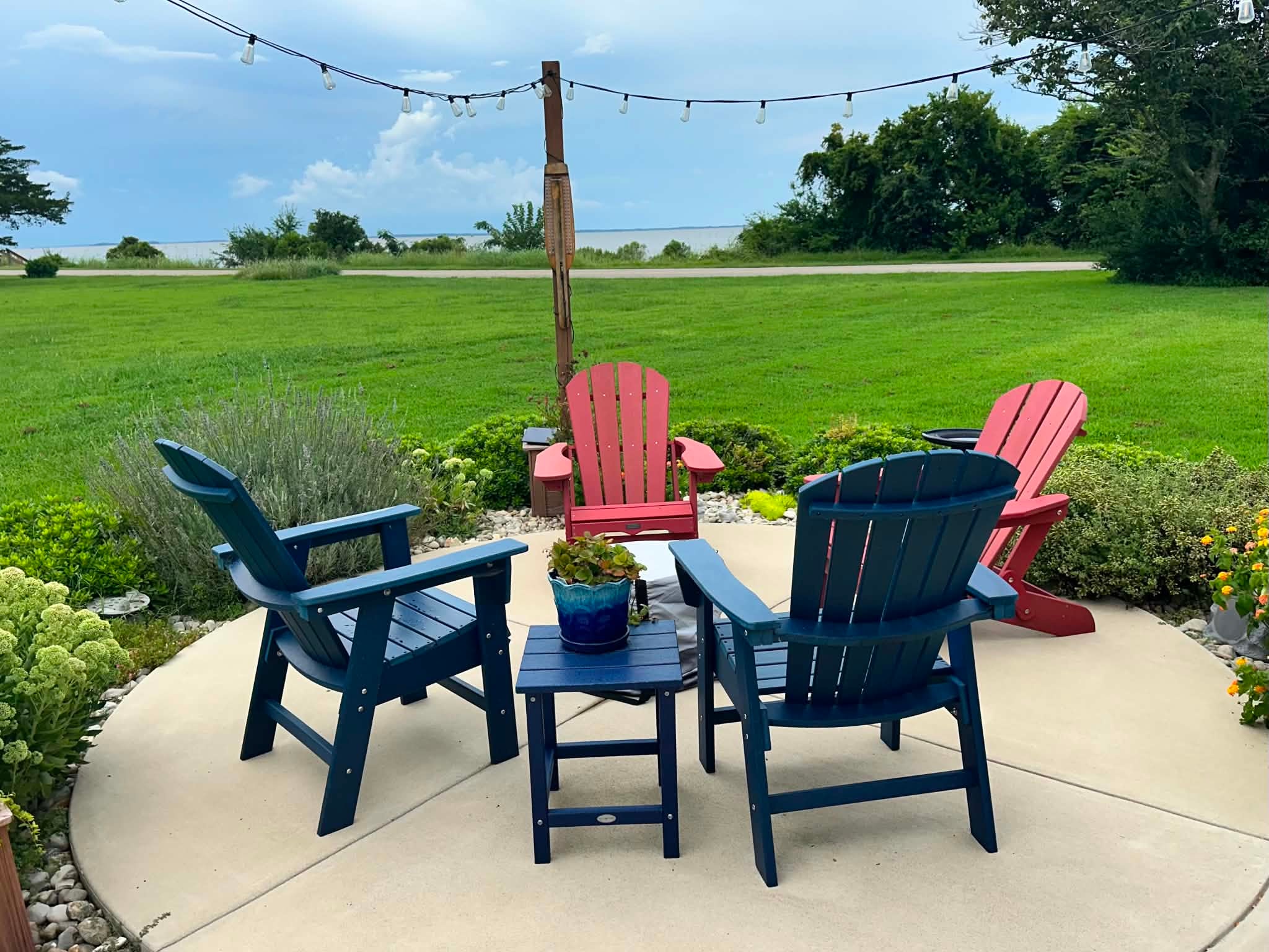 Colorful Adirondack chairs on the landscaped patio overlooking the sound